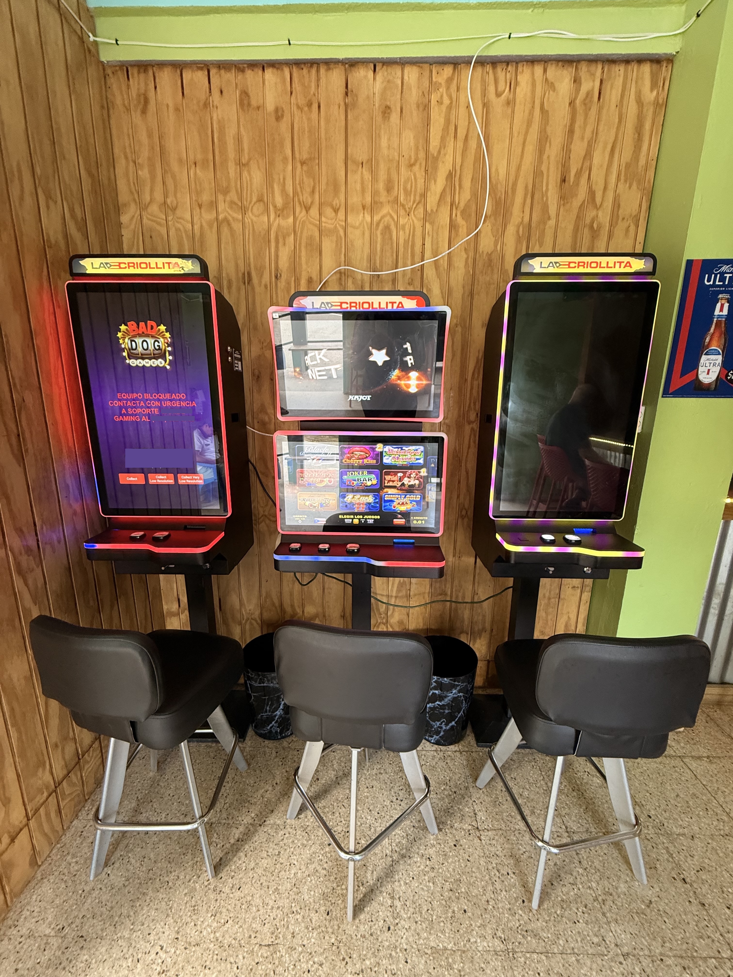 Three machines in a venue: one showing locked screen, one dark, one working